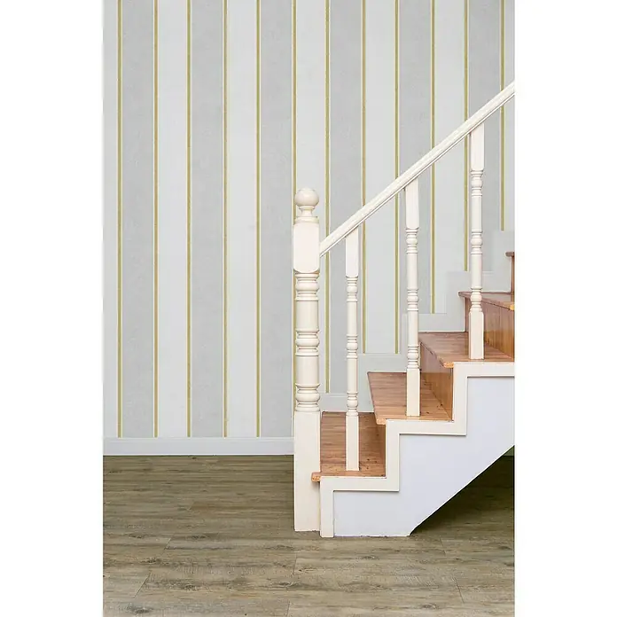 Glööckler Pompöös Provence Vliestapete - Weiß/Grau, Streifen, 10,05 x 0,53 m - Detailaufnahme einer Treppe mit weißem Geländer und Holzstufen vor einer gestreiften Tapete.