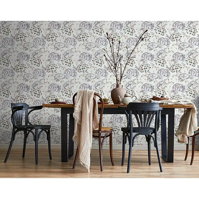 Glööckler Pompöös Provence Vliestapete - Grau/Braun/Lila, Floral, 10,05 x 0,53 m - Ein Esstisch mit Geschirr und Dekoration, umgeben von eleganten Stühlen, vor einer Wand mit floralem Muster.