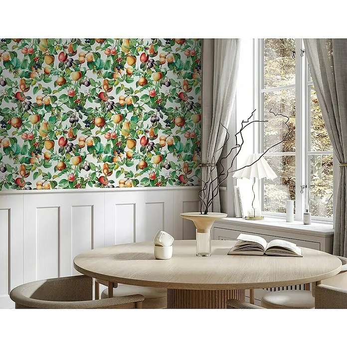 Glööckler Pompöös Provence Vliestapete - Weiß/Grün/Orange, Floral, 10,05 x 0,53 m - Ein runder Holztisch mit Buch und Dekorationen, umgeben von Stühlen, vor einer Wand mit Fruchtmuster.