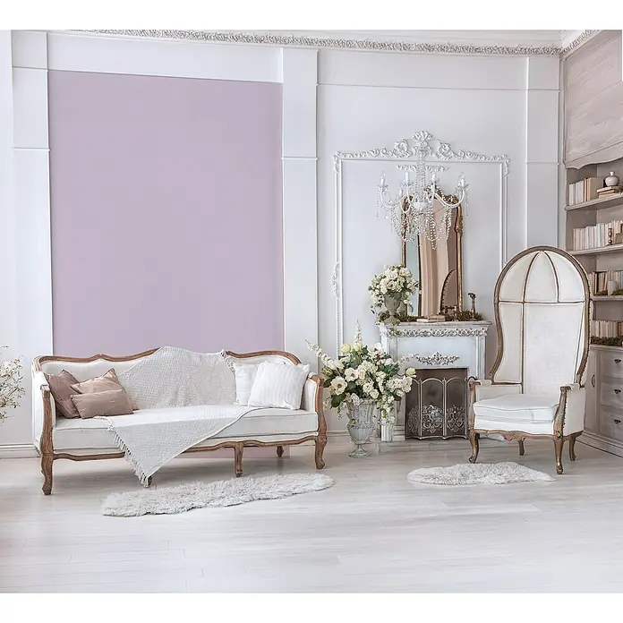Glööckler Pompöös Provence Vliestapete - Rosa, Uni, 10,05 x 0,53 m - Elegantes Interieur mit einem weißen Sofa, einem Ohrensessel und dekorativen Elementen, die eine luxuriöse und einladende Atmosphäre schaffen.