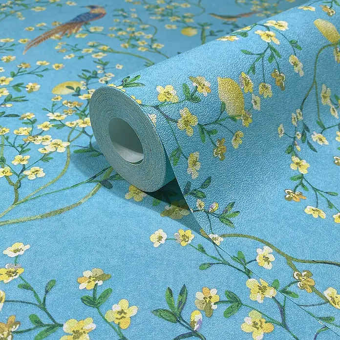 Glööckler Pompöös Provence Vliestapete - Blau/Grün/Gelb, Floral, 10,05 x 0,53 m - Nahaufnahme einer Rolle blauer Tapete mit Blumenmuster und Vogeldesign, ideal für eine stilvolle Wandgestaltung.