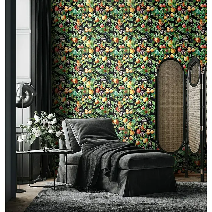Glööckler Pompöös Provence Vliestapete - Schwarz/Grün/Orange, Floral, 10,05 x 0,53 m - Ein stilvolles Interieur mit einer eleganten grauen Chaiselongue, einem dekorativen Raumteiler und einer auffälligen Fruchtmuster-Tapete.