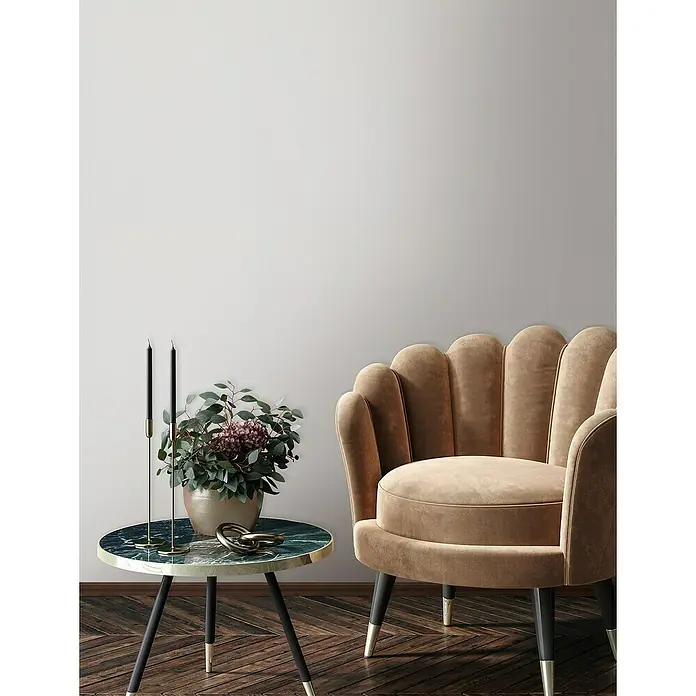 Glööckler Pompöös Provence Vliestapete - Grau/Weiß, Uni, 10,05 x 0,53 m - Elegantes Interieur mit einem beigefarbenen Sessel, einem Marmortisch mit goldenen Akzenten und dekorativen Elementen für ein stilvolles Ambiente.