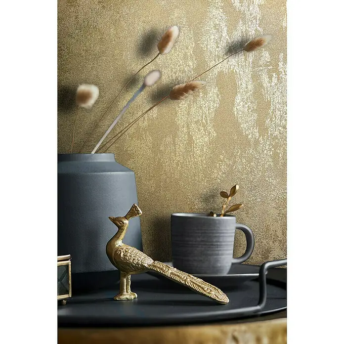 Glööckler Pompöös Provence Vliestapete - Gold, Metalloptik, 10,05 x 0,53 m - Stillleben mit einer goldenen Pfauenfigur, einer grauen Tasse und einer blauen Vase auf einem Tablett vor einem goldenen Hintergrund.
