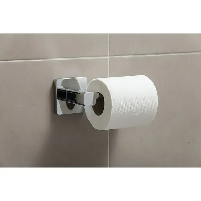 Tatay Kalo Portarrollos papel higiénico - Sin tapa, Cromo - Un primer plano de un portarrollos de papel higiénico con un rollo completo de papel higiénico en una pared de baño gris.