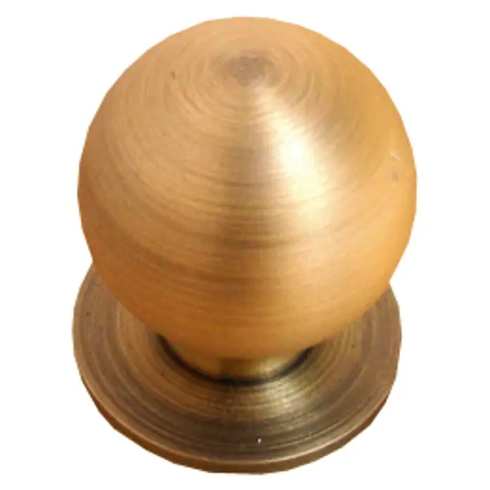 Nesu Pomo para muebles 24515 - Ø x Al: 23 x 27 mm, Acero, Dorado - Primer plano de un pomo de mueble esférico dorado con círculos concéntricos sobre una base redonda contra un fondo negro.