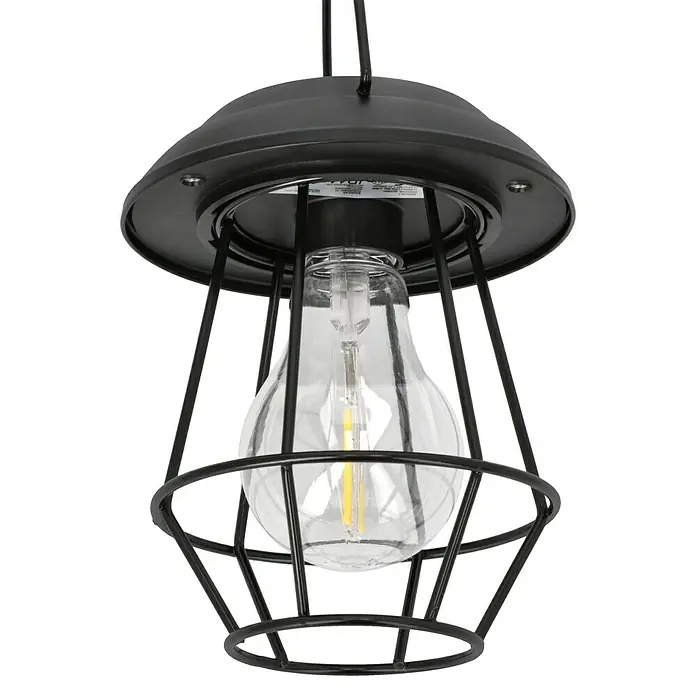 BAUHAUS Solar-Erdspieß Laterne - 0,06 W, L x B x H: 12 x 12 x 78 cm, Schwarz, IP44, 7,2 lm - Nahaufnahme einer schwarzen Käfig-Pendelleuchte mit einer klaren Glühbirne, die ein warmes Licht ausstrahlt. Das Design ist industriell und modern.