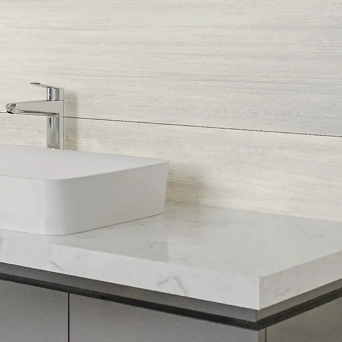 Wandfliese Layers Bone Base - 30 x 90 cm, Elfenbein, Matt - Nahaufnahme eines modernen Waschbeckens mit Marmorplatte und chromfarbenem Wasserhahn vor einer hellen Holzwand.