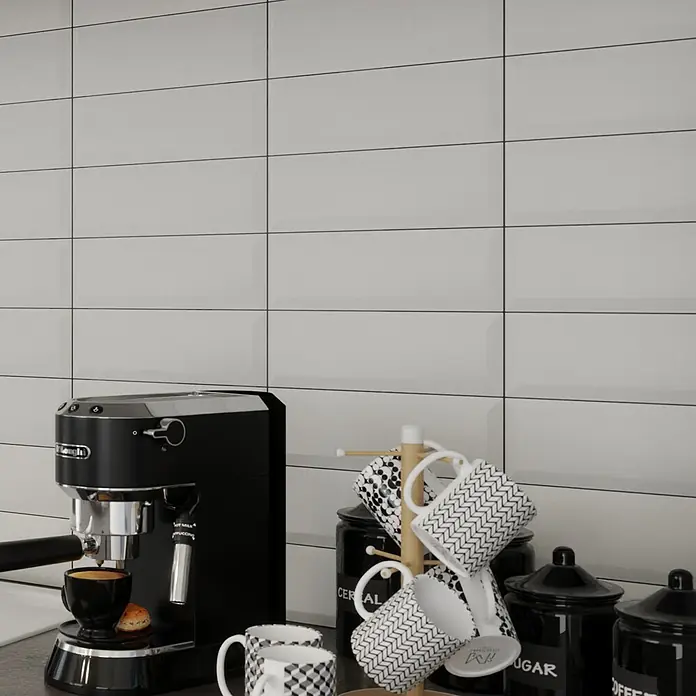 Modern Style Wandfliese Metro Biselado - 9,8 x 29,8 cm, Weiß, Matt - Nahaufnahme einer DeLonghi Espressomaschine mit Tassen, Kaffeekannen und Wandfliesen im Hintergrund.