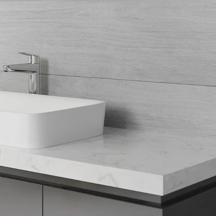 Wandfliese Spa Perla Base - 30 x 90 cm, Grau, Matt - Detailaufnahme eines modernen Badezimmerwaschtischs mit weißem Aufsatzwaschbecken, Armatur und einer Marmorplatte.