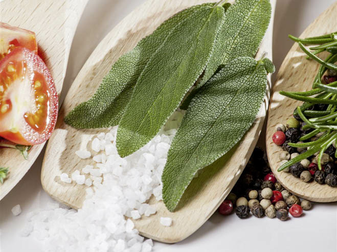 Kochlöffel mit Sabei, Salz, Tomate, Rosmarin und Pfeffer darauf