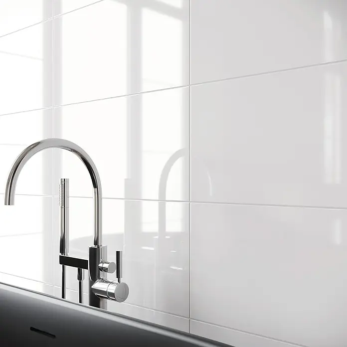 Wandfliese Basic30 x 60 cm, Weiß, Glänzend - Elegante Badarmatur vor glänzenden, weißen Fliesen. Modernes Design trifft auf hochwertige Materialien für ein luxuriöses Badezimmerambiente.