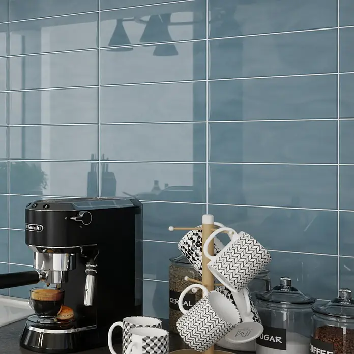Modern Style Wandfliese Emotion Azul 730 - 9,8 x 29,8 cm, Blau, Glänzend - Detailaufnahme einer eleganten Delonghi Espressomaschine mit Tassen und Behältern vor blauem Fliesenspiegel.