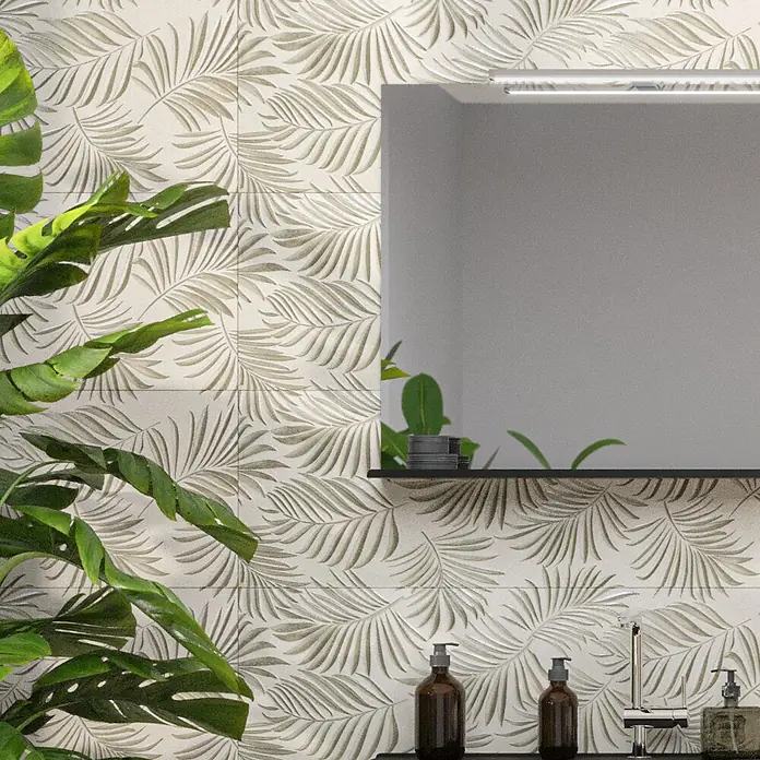 Wandfliese Palmeto Dekor Perla - 30 x 90 cm, Hellgrau, Matt - Wandfliesen mit Blätterdruck in einem Badezimmer mit Spiegel und dekorativen Accessoires.