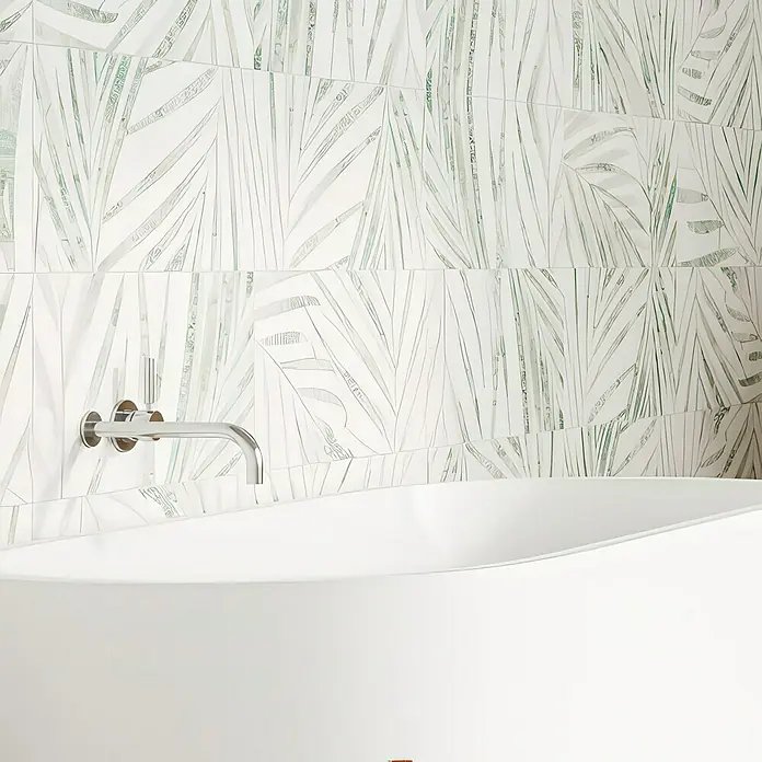 Domicil Wandfliese Living Concrete Goldfruit - 30 x 60 cm, Hellgrün/Weiß, Matt - Eine moderne Badewanne mit elegantem Chromhahn vor einer Wand mit Blattmusterfliesen, die dem Raum einen stilvollen Akzent verleihen.