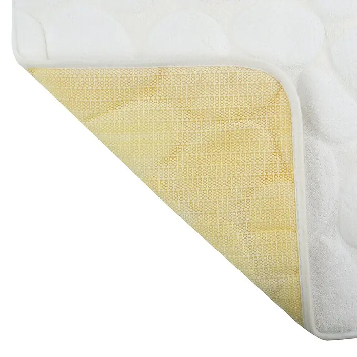 MSV Alfombra de baño Piedras B - 80 x 50 cm, Poliéster, Blanco - Primer plano de un protector de colchón con una superficie blanca acolchada y una parte inferior amarilla con puntos antideslizantes.