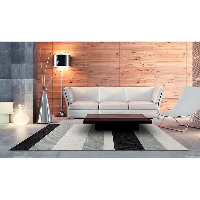 Alfombra de vinilo Living Stripes - Gris, 180 x 120 cm - Un salón moderno con una alfombra de rayas, un sofá blanco y una mesa de madera oscura.