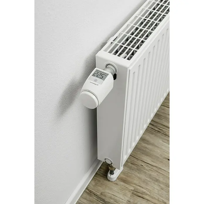 Homematic IP Heizkörper-Thermostat HmIP-eTRV-2 - Ventilanschluss: M30 x 1,5 mm, Batteriebetrieben, 97 x 58 x 71 mm, Weiß, 1 Stk. - Ein weißer Heizkörper mit einem Homematic IP Thermostat, der auf 22,5 Grad Celsius eingestellt ist, steht an einer weißen Wand.