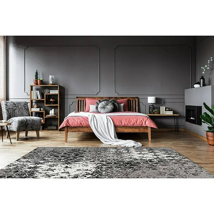 Kayoom Kurzflorteppich Iglesia - Grau, 170 x 120 cm, 100 % Polyester - Ein stilvolles Schlafzimmer mit einem grauen Teppich mit abstraktem Muster, einem Holzbett und einer gemütlichen Leseecke.