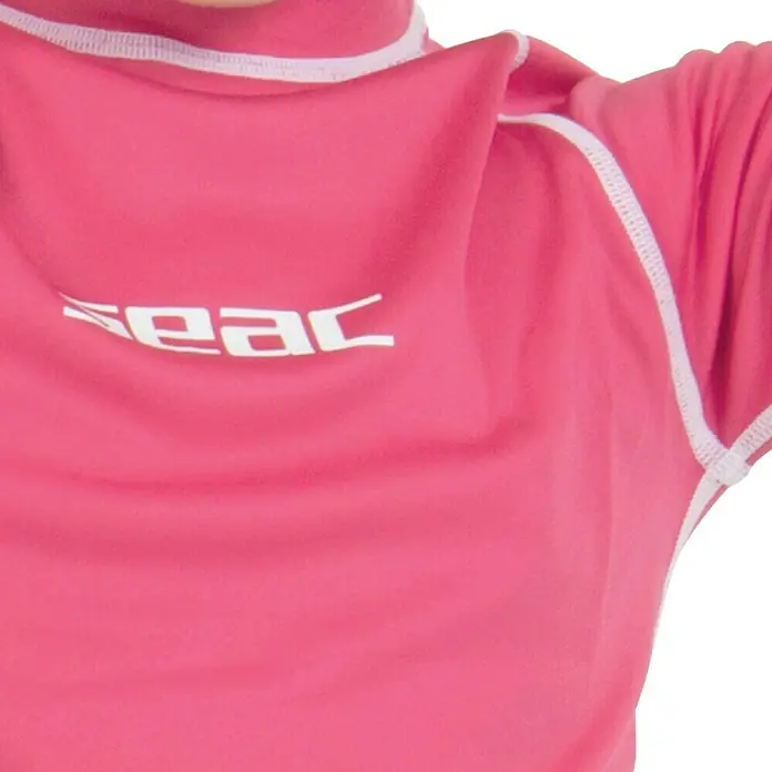 Seac Sub Camiseta térmica T-Sun Long - Apto para: Niños, 5 años, Rosa - Primer plano de un rash guard rosa SEAC con costuras blancas y logotipo, ideal para deportes acuáticos y protección solar.
