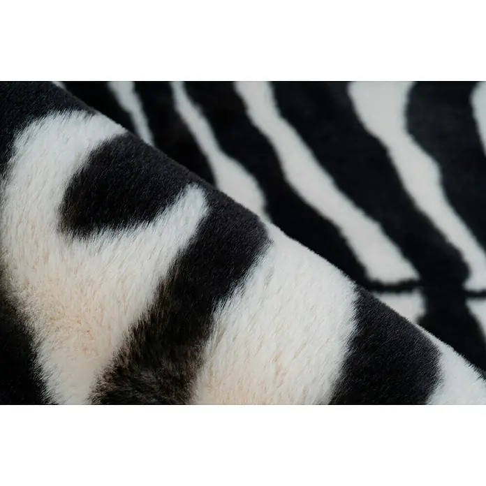Kayoom Hochflorteppich Zebra - Weiß/Schwarz, 160 x 120 cm, 100 % Polyester - Nahaufnahme eines Zebra-Kunstfellteppichs mit weichen, gewellten Streifen, die eine luxuriöse Textur und ein stilvolles Muster zeigen.