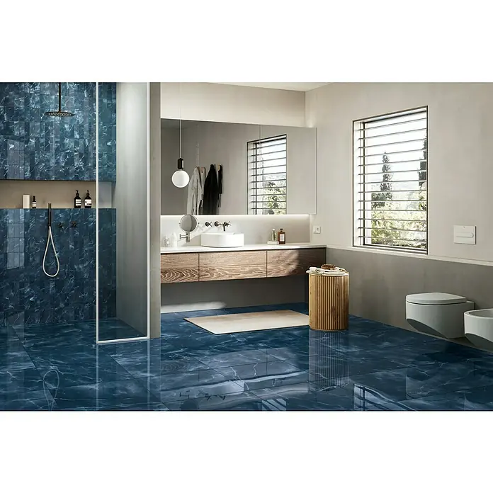 Atlas Concorde Solution Marble Vison Feinsteinzeugfliese Onice Blue - 60 x 60 cm, Blau, Glänzend - Geräumiges Badezimmer mit blauen Marmorfliesen, Holzwaschtisch und minimalistischer Einrichtung für ein modernes Ambiente.