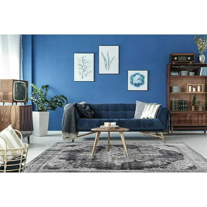 Kayoom Kurzflorteppich Vintage - Grau, 290 x 200 cm, 100 % Polyacryl - Einrichtungsidee mit einem blauen Sofa, einem Holztisch und einem orientalischen Teppich, die eine elegante und gemütliche Atmosphäre schaffen.