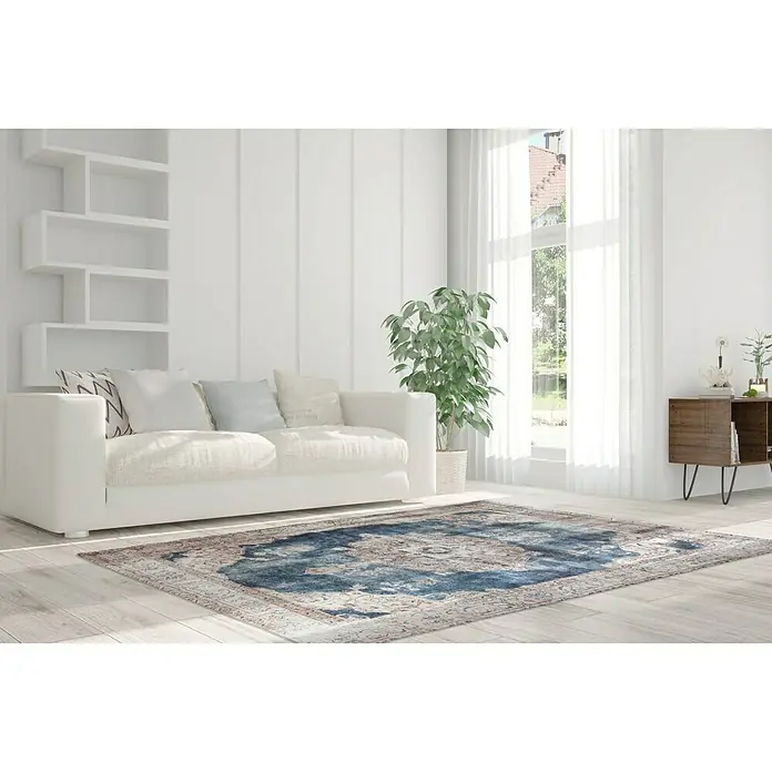 Kayoom Kurzflorteppich Vintage - Creme/Blau, 200 x 140 cm, 100 % Polyacryl - Ein stilvoller Raum mit einem blauen Teppich im Vintage-Stil, der dem Zimmer einen Hauch von Eleganz verleiht. Der Teppich harmoniert mit der Einrichtung.