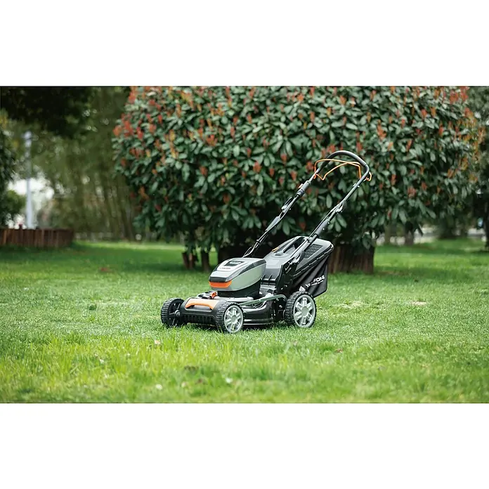 Yard Force Akku-Rasenmäher LM M46B - 60 V, 1 Akku, 4 Ah, Schnittbreite: 46 cm - Ein grau-schwarzer Rasenmäher mit orangefarbenen Akzenten und Fangkorb, auf Rasen in einem Garten.