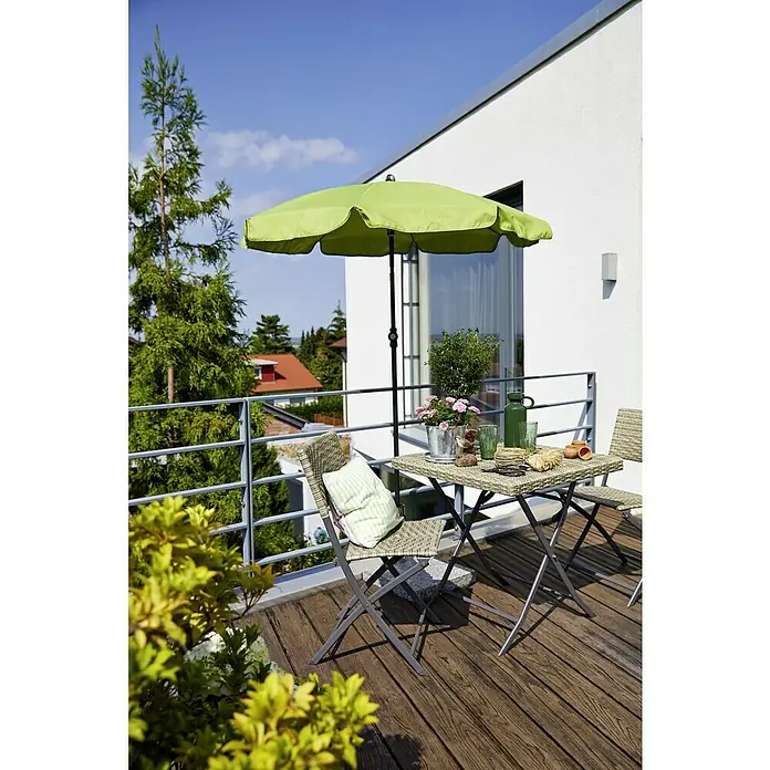 Sunfun Balkonschirm rund Provence II - Apfelgrün, Durchmesser Bespannung: 200 cm - Gartenszene mit einem grünen Sonnenschirm, Tisch und Stühlen auf einer hölzernen Terrasse mit Blick auf die Landschaft.