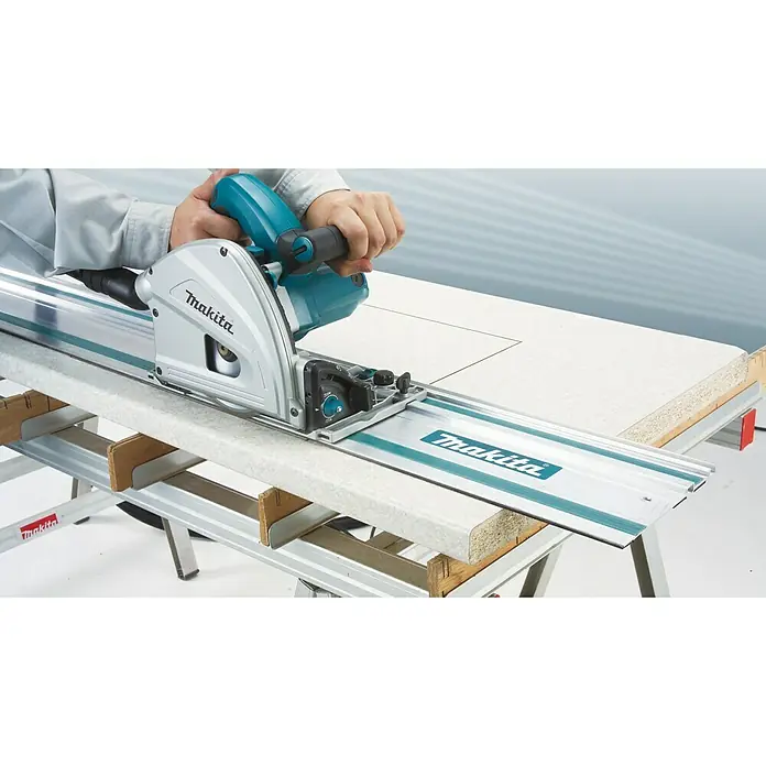 Makita Sierra de inmersión SP6000J1 - 1.300 W, Número de revoluciones de marcha en vacío: 6.400 r.p.m. - Sierra de inmersión Makita en acción. La sierra se desliza con precisión sobre una guía, ideal para cortes limpios y rectos.