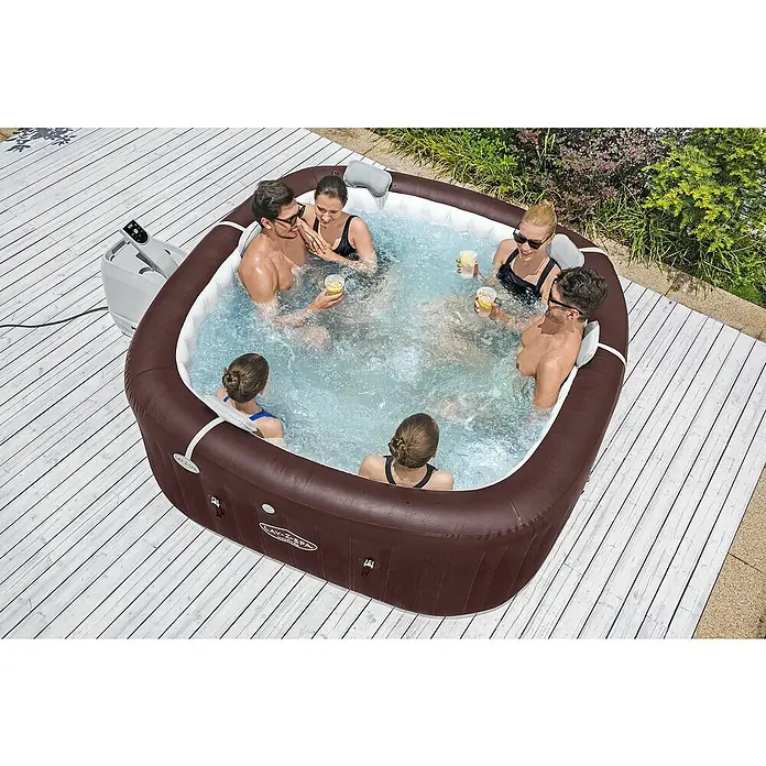 Bestway Lay-Z-Spa Mobil-Whirlpool Maldives HydroJet - L x B x H: 201 x 201 x 80 cm, Mahagoni, 1.050 l - Brauner und weißer Lay-Z-Spa aufblasbarer Whirlpool mit sechs Personen, die im Freien auf einem Deck Blasen genießen.