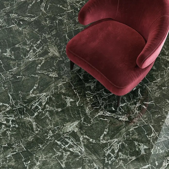 Atlas Concorde Solution Marble Vison Feinsteinzeugfliese Verde Bosco - 60 x 60 cm, Grün, Glänzend - Nahaufnahme eines eleganten roten Sessels auf einem grünen Marmorboden, der die luxuriöse und stilvolle Einrichtung betont.