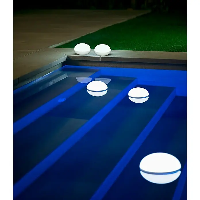 New Garden LED-Poolbeleuchtung Coco Floating Blulb - Durchmesser: 11 cm, Weiß, LED - Stimmungsbild: Eine Reihe runder Leuchten, einige davon schwimmen in einem blauen Pool und beleuchten die Umgebung sanft.