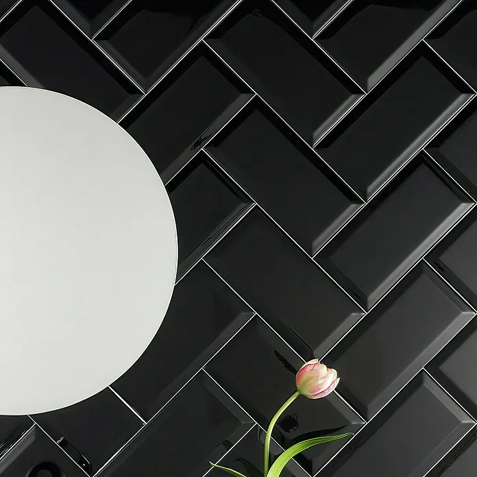Wandfliese Metro - 10 x 20 cm, Schwarz, Glänzend - Schwarze, glänzende Ziegelwand mit stilvoller Fischgrätenmusterung, ergänzt durch eine elegante weiße Scheibe und eine zarte Tulpe.