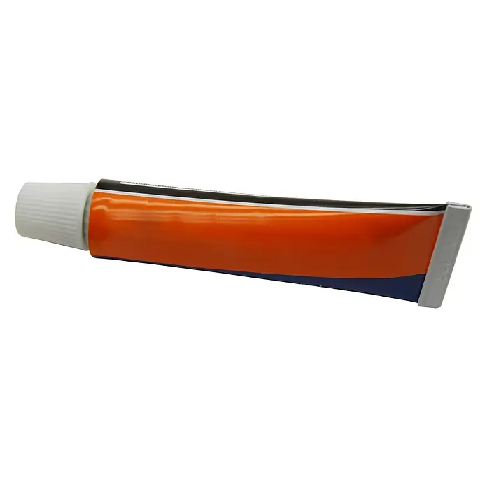 CM Baños Kit de fijación genérico KITACC - Apto para: Utensilios de baño - Primer plano de un tubo de pomada con centro naranja, franja negra y tapón blanco.