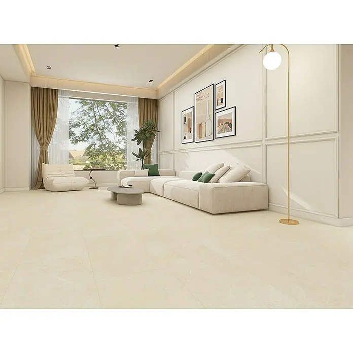 Vinylbodenmuster Rigid Concrete Sahara - 297 x 180 x 3,5 mm, Steinoptik - Helle, geräumige Wohnzimmeransicht mit beigem Sofa, Sessel und goldenem Bogenlampe. Dekorative Wandpaneele und große Fenster sorgen für ein einladendes Ambiente.