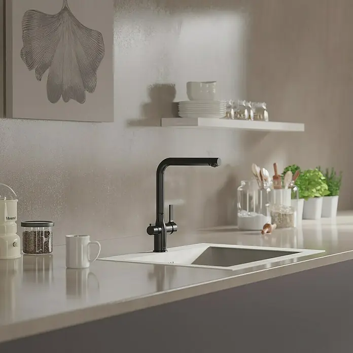 Camargue Spültischarmatur Blueperl - Schwarz, Matt - Elegante Küche mit modernem schwarzen Wasserhahn, eingebaut in eine stilvolle Arbeitsplatte mit Spüle. Geschirr und Deko vervollständigen das Bild.