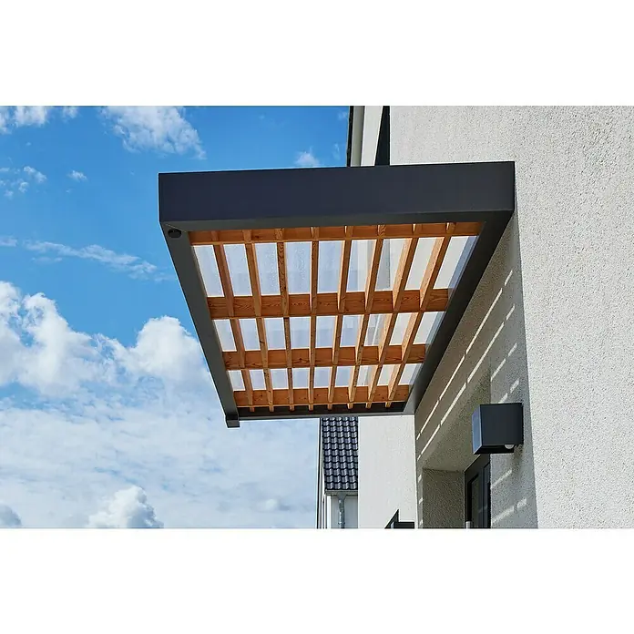 Gutta Rechteckvordach BS Timber-Line - 200 x 90 x 12,5 cm - Nahaufnahme eines modernen Vordachs mit Holzlamellen und einer transparenten Abdeckung an einer Hauswand, mit blauem Himmel im Hintergrund.