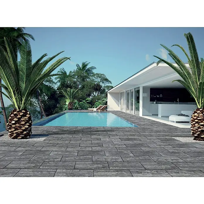 Terrassenplatte Latina - 48 x 24 x 3 cm, Grau/Schwarz, Beton - Luxuriöses Pooldeck mit grauen Pflastersteinen, umgeben von üppiger tropischer Vegetation und einem modernen Haus im Hintergrund.