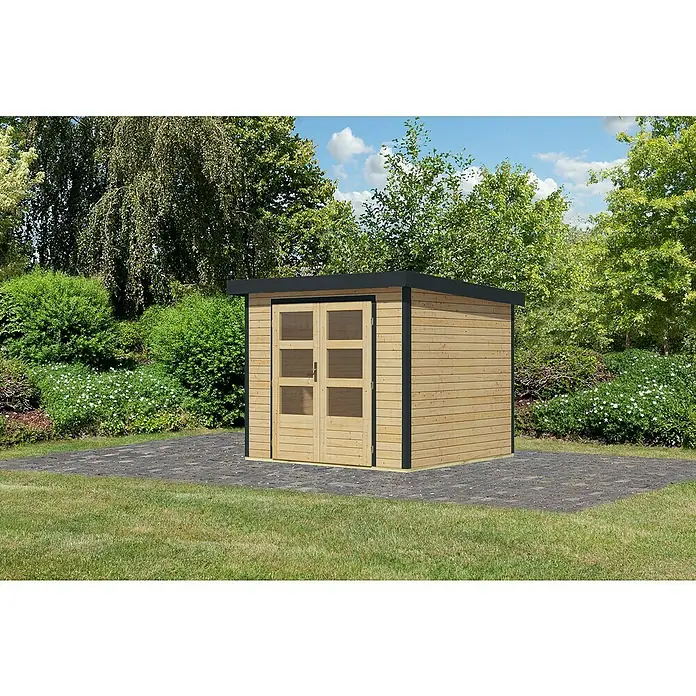 Karibu Gartenhaus Jupiter 3 A - Außenmaß inkl. Dachüberstand (B x T): 266 x 236,5 cm, Holz, Naturbelassen - Ein modernes Gartenhaus mit Doppeltür und Holzverkleidung auf einem gepflasterten Untergrund vor üppigem Grün.