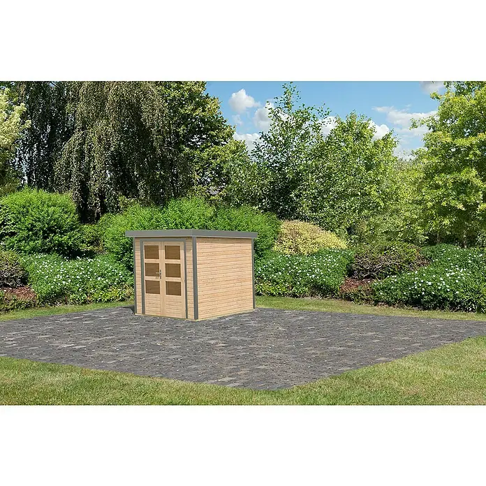 Karibu Gartenhaus Jupiter 2 A - Außenmaß inkl. Dachüberstand (B x T): 228,5 x 235 cm, Holz, Naturbelassen - Holzgartenhaus mit Doppeltür auf gepflasterter Fläche, umgeben von üppigem Grün. Ideal zur Aufbewahrung von Gartengeräten und Werkzeugen.