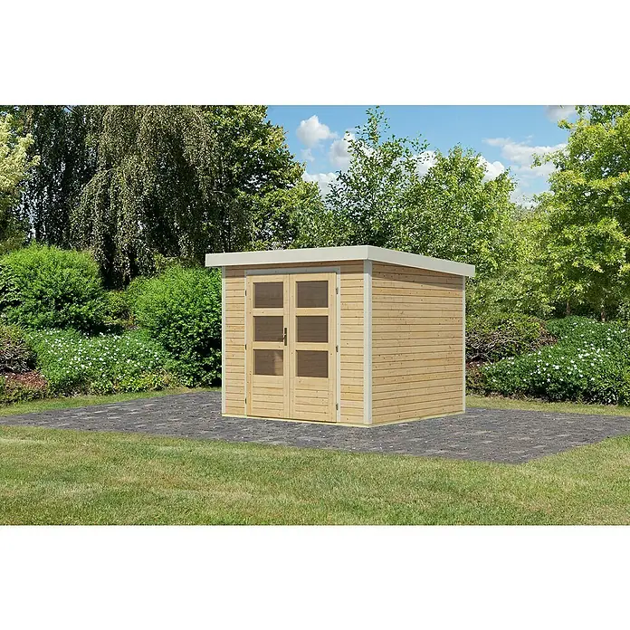 Karibu Gartenhaus Jupiter 3 A - Außenmaß inkl. Dachüberstand (B x T): 266 x 236,5 cm, Holz, Naturbelassen/Weiß - Holzgartenhaus mit Doppeltür und Flachdach auf gepflasterter Fläche. Das Gartenhaus ist umgeben von Grünflächen und Bäumen.