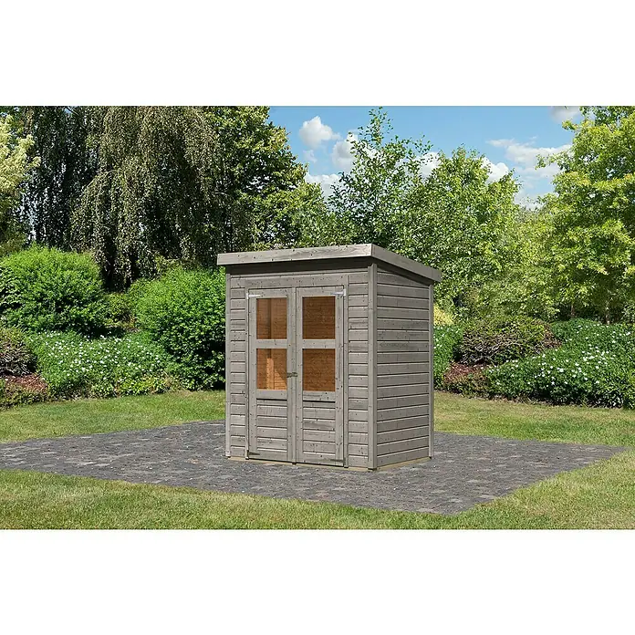Karibu Gartenhaus Merseburg 2 - Außenmaß inkl. Dachüberstand (B x T): 189 x 142 cm, Holz, Vorvergraut, Ohne Seitendach - Ein graues Holzgartenhaus mit Doppeltür und Fenstern steht auf einer Terrasse mit Grünfläche im Hintergrund.