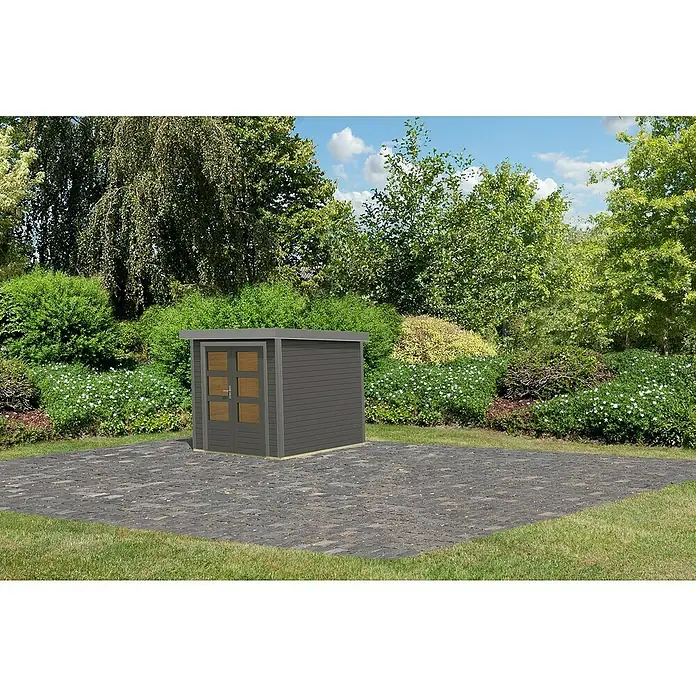 Karibu Gartenhaus Jupiter 2 B - Außenmaß inkl. Dachüberstand (B x T): 228,5 x 235 cm, Holz, Terragrau - Ein graues Gartenhaus mit Doppeltür auf einer gepflasterten Fläche, umgeben von üppigem Grün und Bäumen unter blauem Himmel.