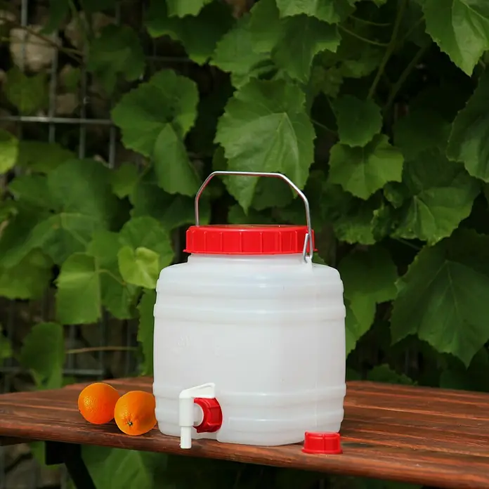 Floraworld Getränkefass Standard - Fassungsvermögen: 5 l - Weißer Kunststoffbehälter mit rotem Deckel und Auslaufhahn auf einem Holztisch, ideal für Flüssigkeiten.