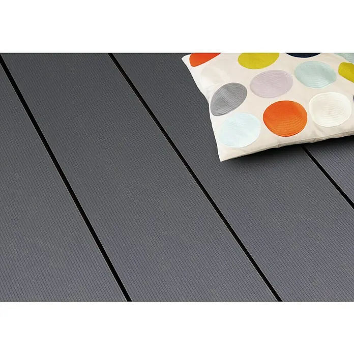 Kovalex WPC-Terrassendiele Massiv Xtra nach Maß - Steingrau, 100 x 26 x 2 cm - Nahaufnahme von Terrassendielen aus WPC mit Kissen, die eine attraktive und pflegeleichte Option für Außenbereiche bieten.