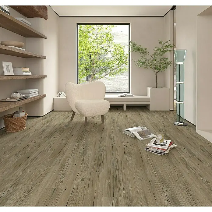 Suelo vinílico autoadhesivo Wild Grey - 152,4 x 914,4 x 2 mm, Gris - Interior acogedor con un sillón elegante, suelo de madera natural y un toque de vegetación, creando un ambiente relajante y elegante.