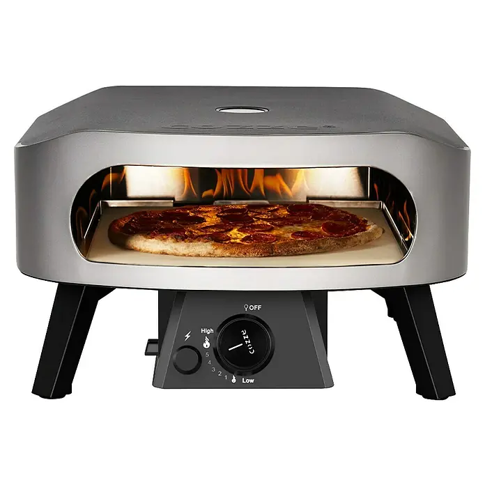 Cozze Pizzaofen Classic 13 - Grillfläche (B x T): 34 x 34 cm, 6 kW - Silberner Pizzaofen mit schwarzem Sockel und Drehknopf, backt eine Peperoni-Pizza mit sichtbaren Flammen.