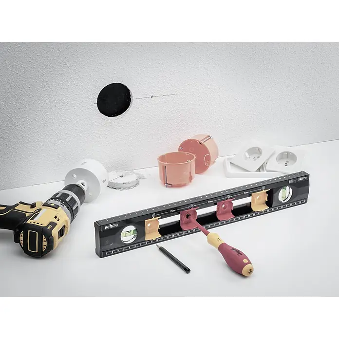 Wiha Elektriker-Wasserwaage - Länge: 400 mm, Anzahl Libellen: 2 Stk. - Wiha Werkzeuge für Elektroinstallation: Eine Bohrmaschine, eine Wasserwaage, Steckdosen und Installationsdosen liegen auf dem Tisch, bereit für die Arbeit.